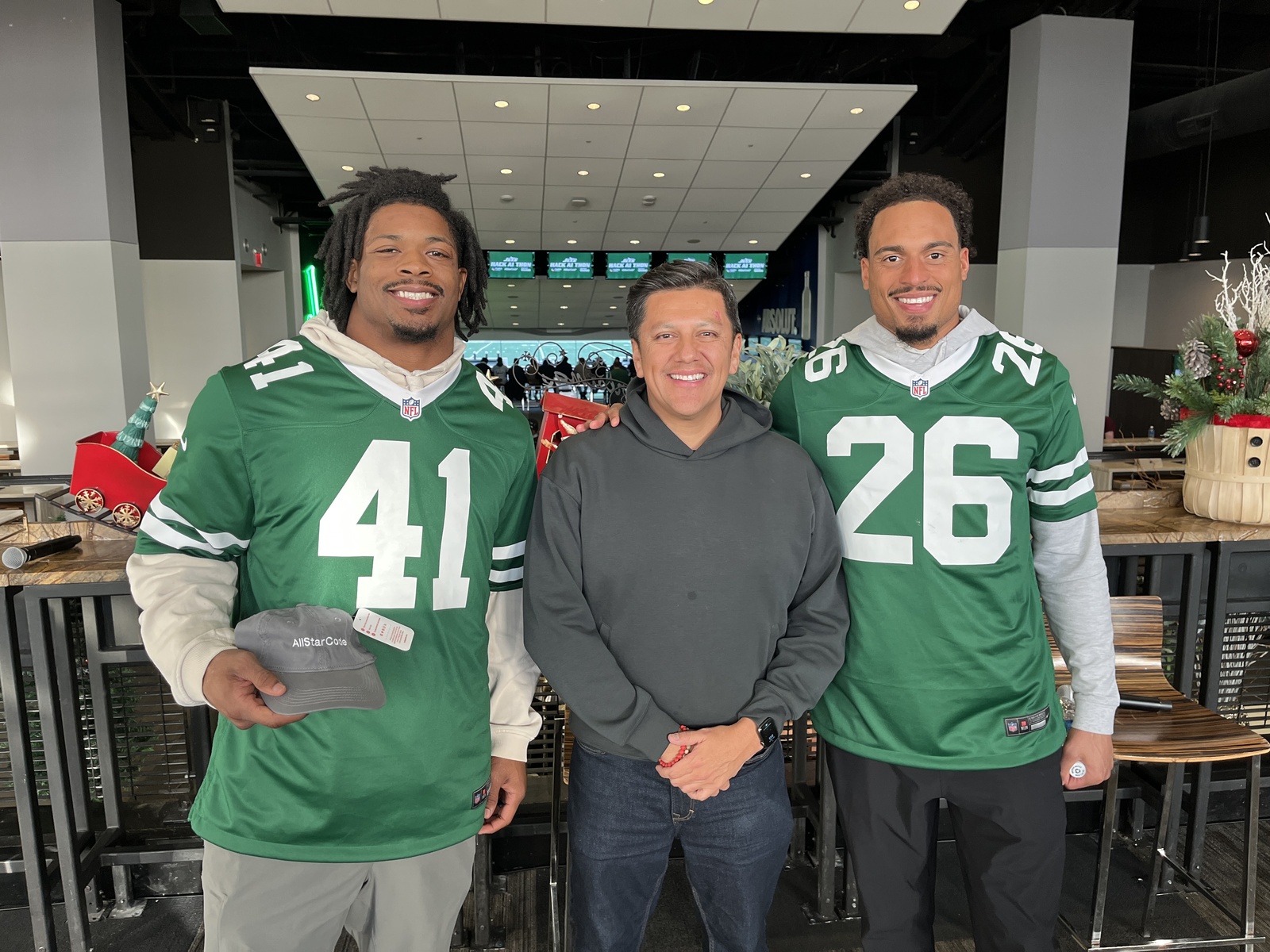Danny Rojas with two New York Jets players at the Hack-AI-Thon